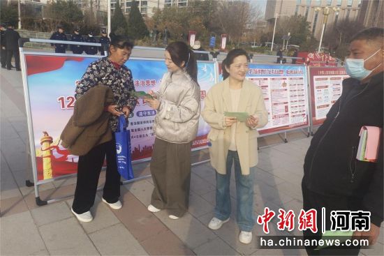 图为工作人员向群众讲解宣传手册内容。